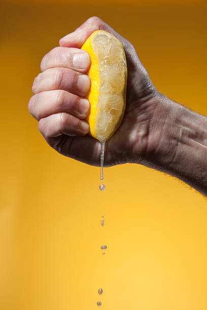 Een citroen wordt uitgeperst in een hand